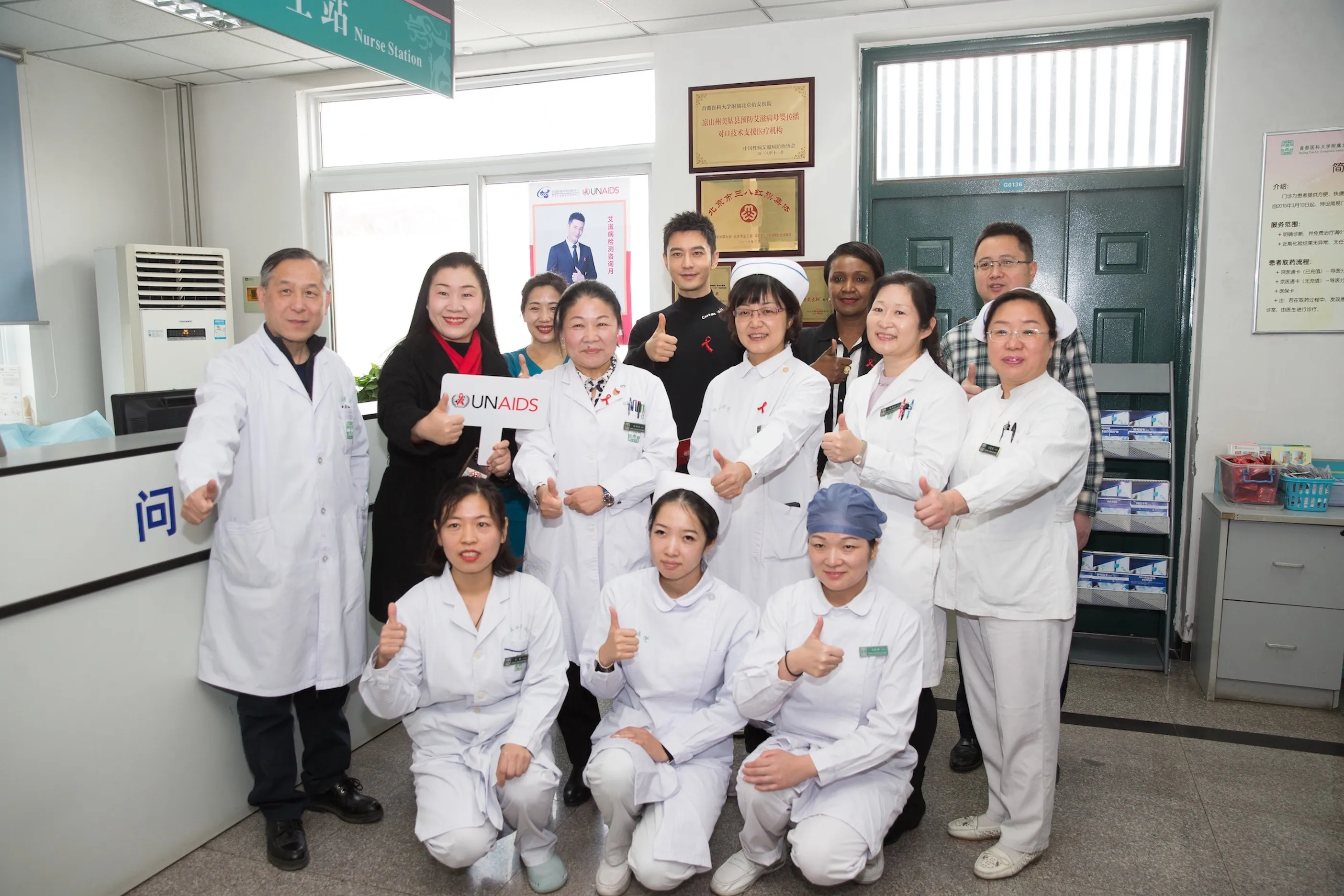 Xiaoming Huang, unaids goodwill ambassador, with laboratory staff and volunteers. Jpeg
