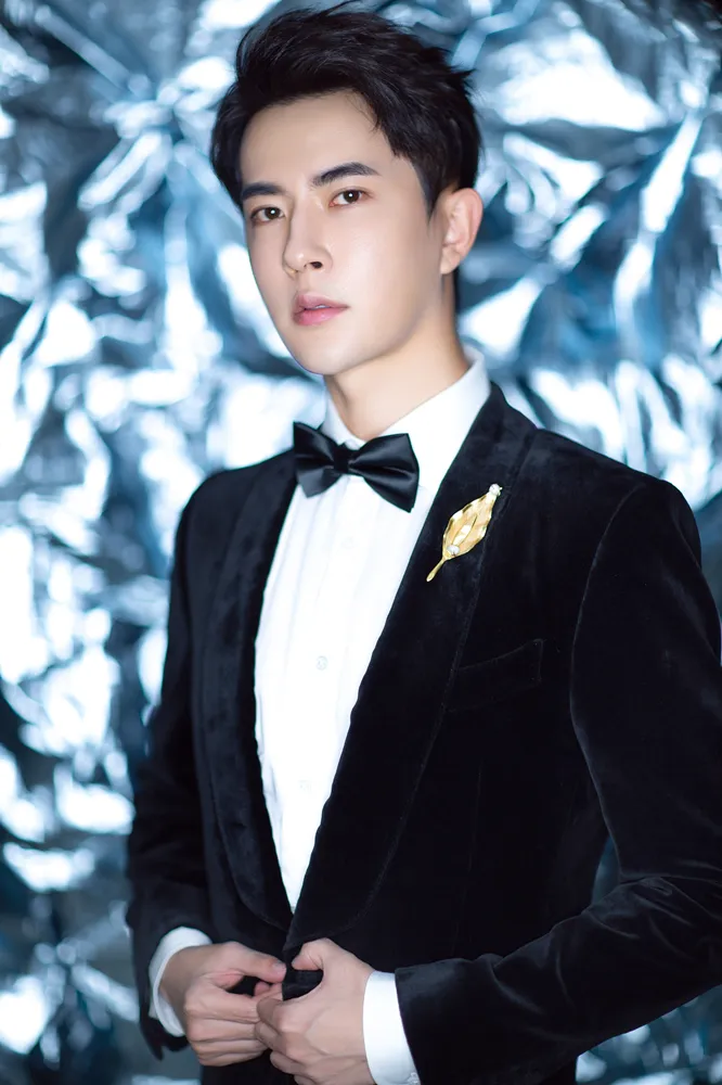 Meng-long Yu black suit with gold brooch. Jpeg