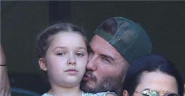 David Beckham, with his family, watches the game as he kisses his daughter, the seven round father.